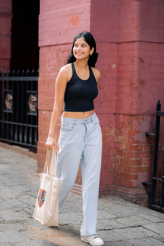 A model holding a canvas tote bag that was made in sri lanka