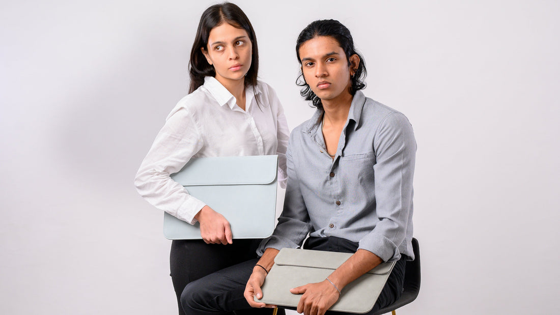 Two people holding light gray folders against a white background