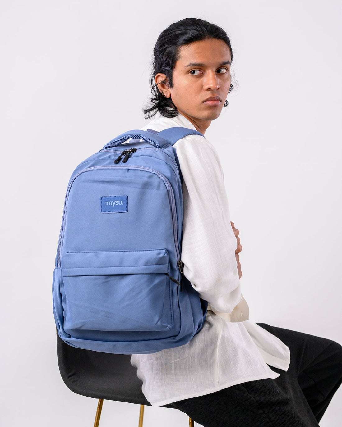Person wearing a blue backpack with a visible brand logo on a white background