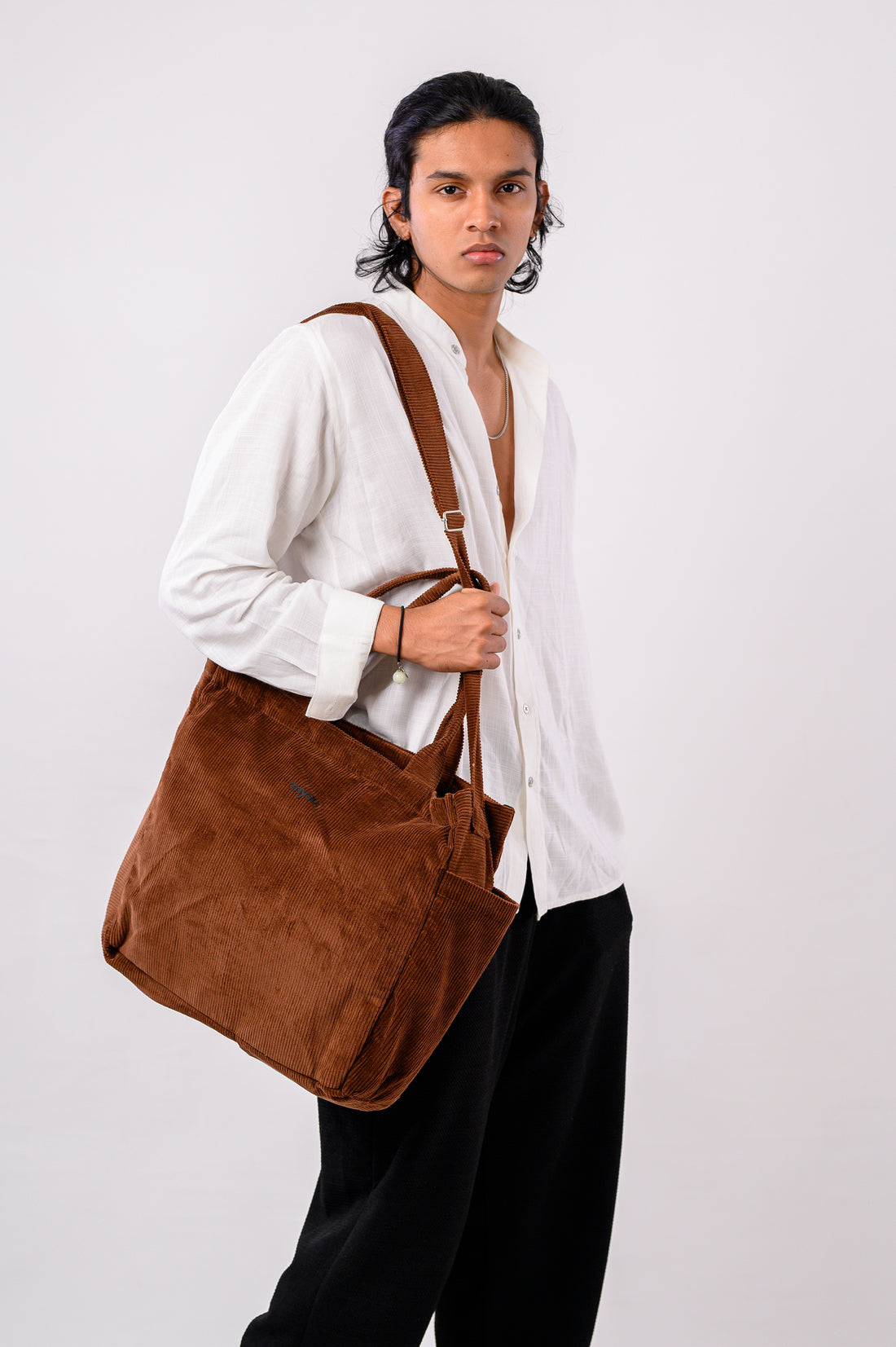 Man holding a brown bag against a white background